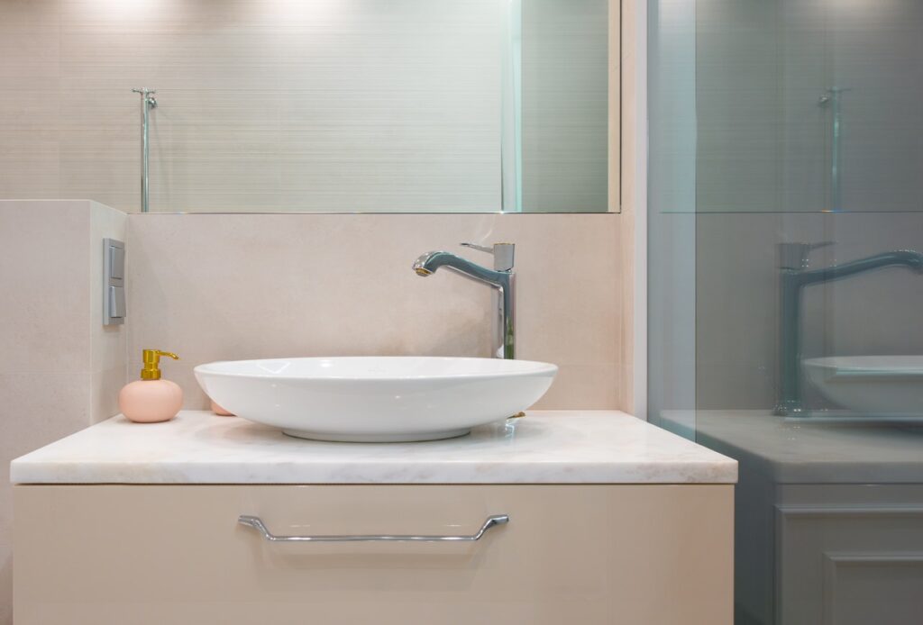 Bathroom with sink and soap dispenser.